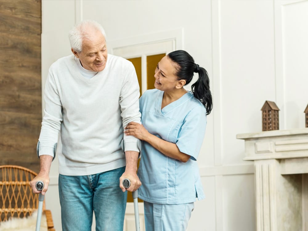 Nurse helping man on crutches