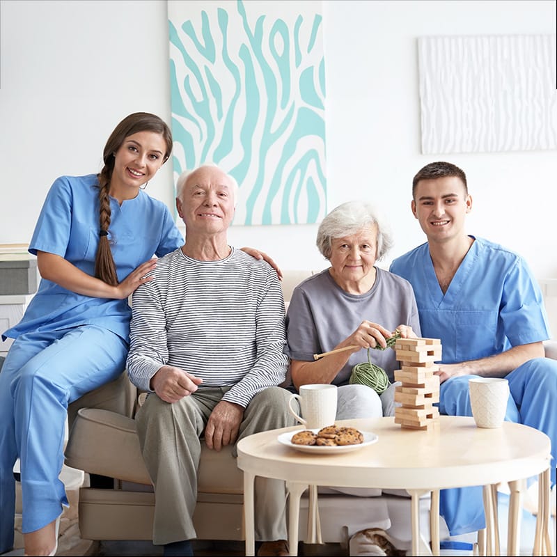 Nurse team posing with elderly couple